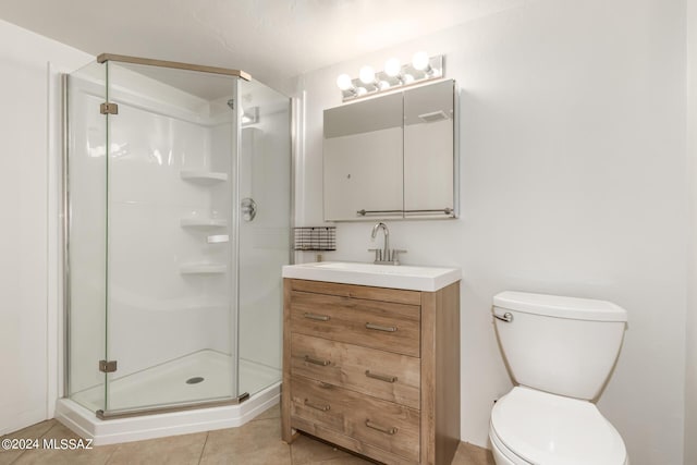 bathroom featuring tile patterned floors, vanity, toilet, and a shower with door