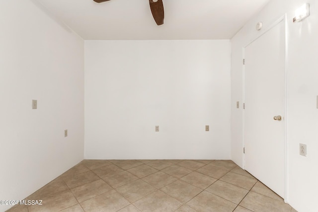 tiled spare room with ceiling fan