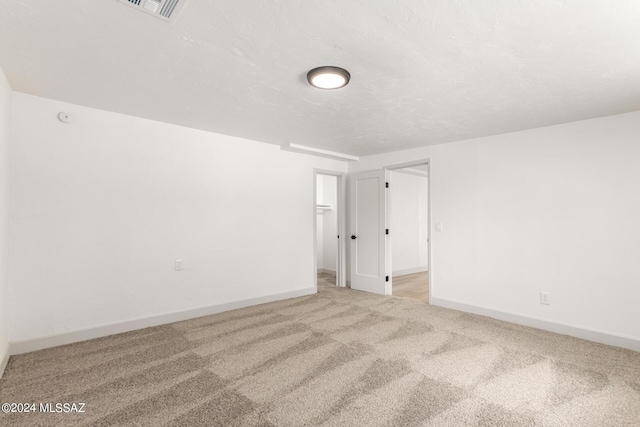 spare room featuring light colored carpet