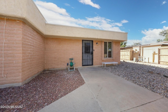 view of exterior entry featuring a patio area