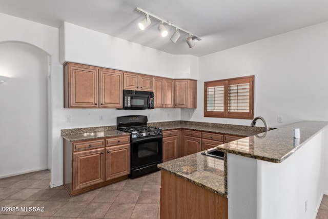 kitchen with light tile patterned floors, black appliances, dark stone counters, and kitchen peninsula