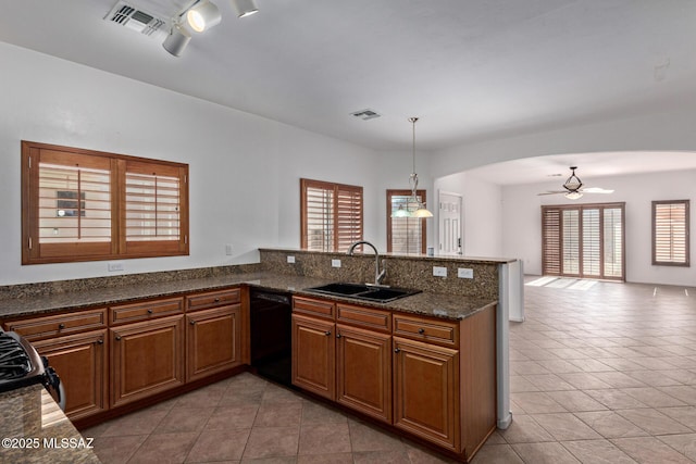 kitchen featuring decorative light fixtures, black dishwasher, sink, and kitchen peninsula