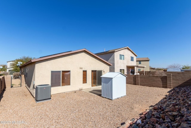 rear view of house with a patio, central AC, and a storage shed