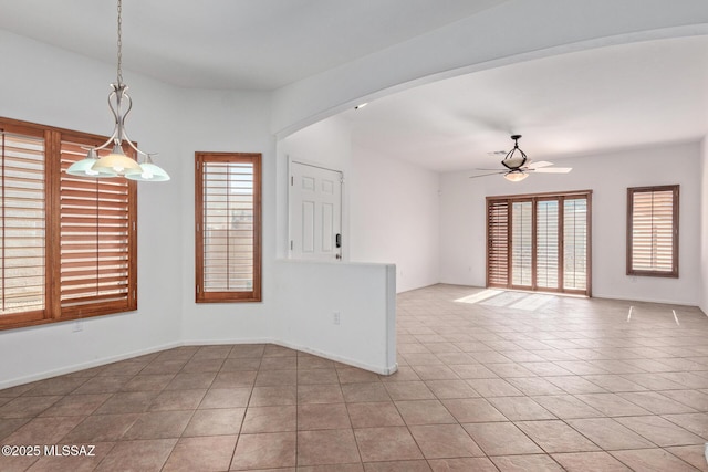 unfurnished room featuring ceiling fan, light tile patterned floors, and a healthy amount of sunlight