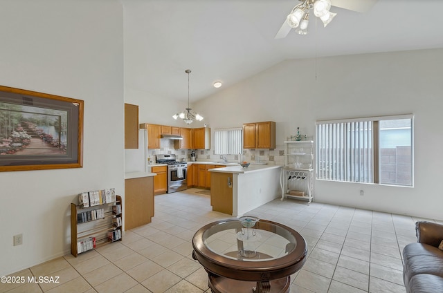 living area with high vaulted ceiling, a wealth of natural light, light tile patterned flooring, and ceiling fan with notable chandelier