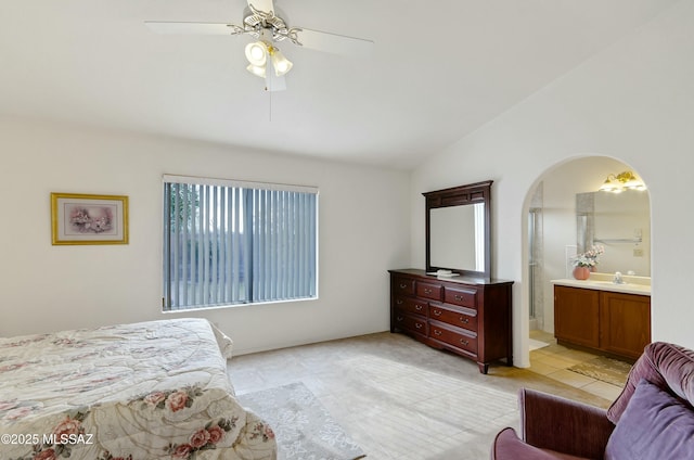 tiled bedroom featuring vaulted ceiling, ceiling fan, and ensuite bath