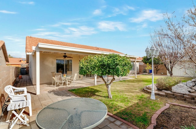 back of property with ceiling fan, a patio, a fenced backyard, a lawn, and stucco siding