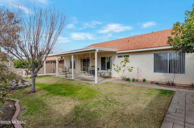 rear view of property with a lawn, a patio, and ceiling fan