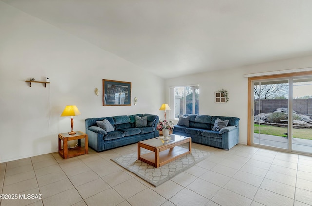 living room with light tile patterned flooring, a healthy amount of sunlight, and lofted ceiling