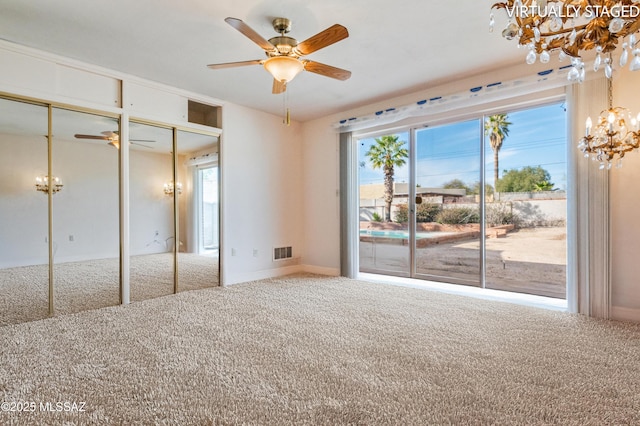 unfurnished bedroom with carpet flooring, access to exterior, a notable chandelier, and two closets