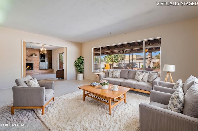 carpeted living room with a brick fireplace and a chandelier