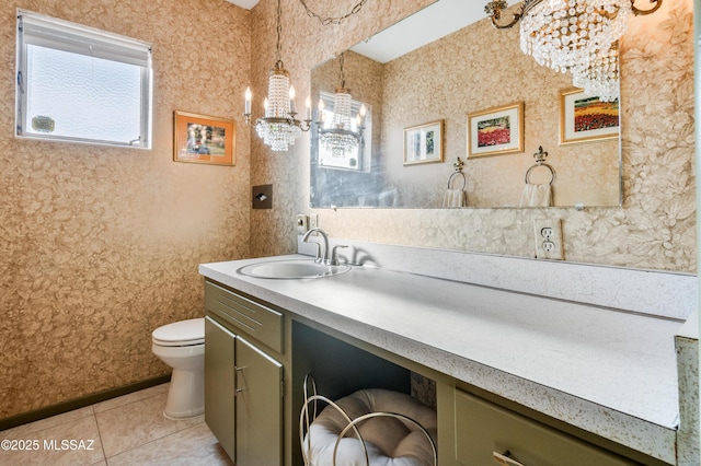 bathroom featuring tile patterned flooring, vanity, toilet, and an inviting chandelier