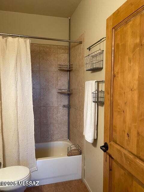 bathroom with toilet and shower / bathtub combination with curtain