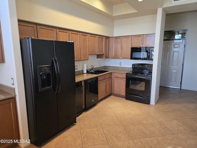 kitchen with sink, black appliances, and light tile patterned flooring