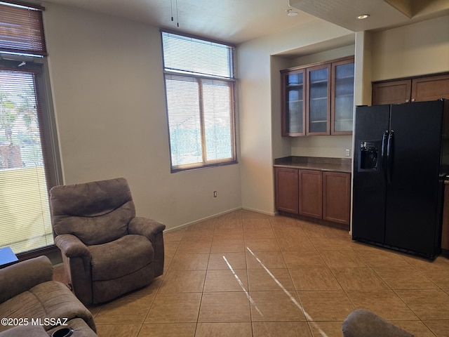 kitchen featuring black fridge and light tile patterned flooring