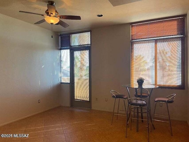 unfurnished dining area with tile patterned flooring, a wealth of natural light, and ceiling fan