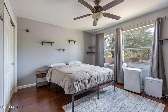 bedroom featuring dark wood-type flooring, a closet, and ceiling fan