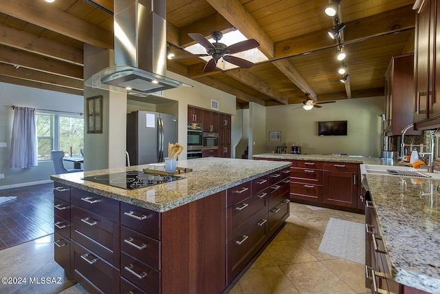 kitchen with stainless steel refrigerator, beam ceiling, island range hood, a kitchen island, and black electric cooktop