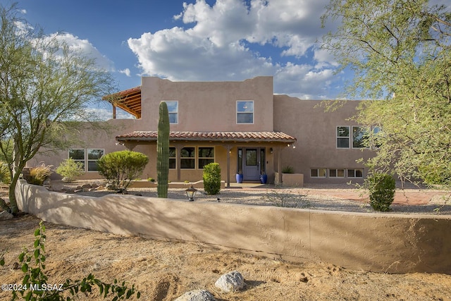 southwest-style home featuring stucco siding and a tile roof