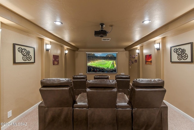 carpeted home theater featuring visible vents and baseboards