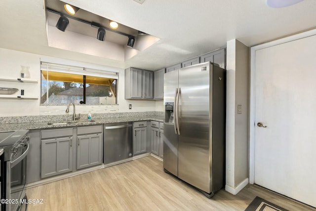 kitchen featuring light hardwood / wood-style flooring, sink, gray cabinets, and stainless steel appliances