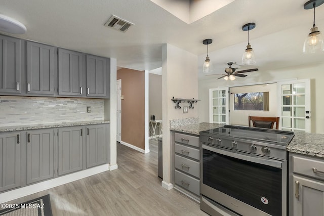 kitchen featuring tasteful backsplash, pendant lighting, stainless steel electric range oven, and gray cabinetry