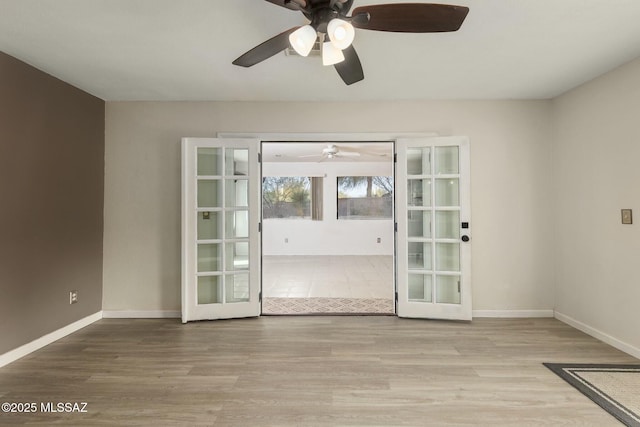 unfurnished room featuring french doors, ceiling fan, and light wood-type flooring