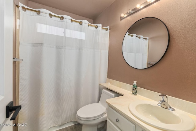 bathroom with vanity, curtained shower, and toilet