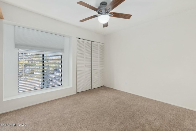 unfurnished bedroom with ceiling fan, a closet, and carpet