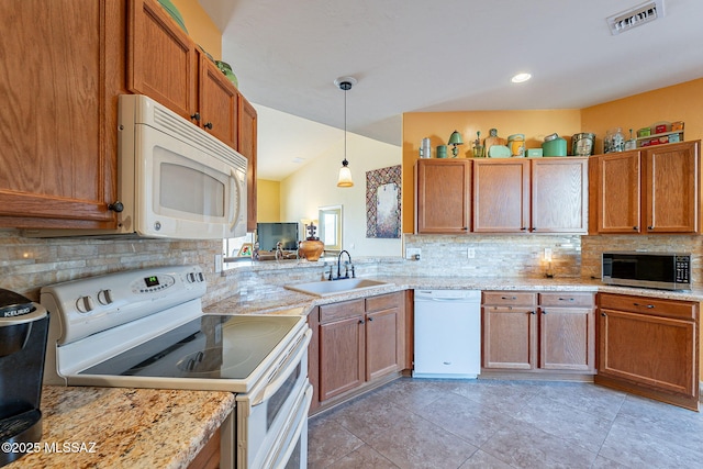 kitchen with sink, tasteful backsplash, hanging light fixtures, white appliances, and light stone countertops