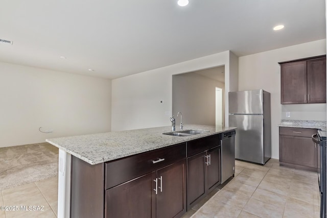 kitchen featuring an island with sink, appliances with stainless steel finishes, sink, and light tile patterned floors