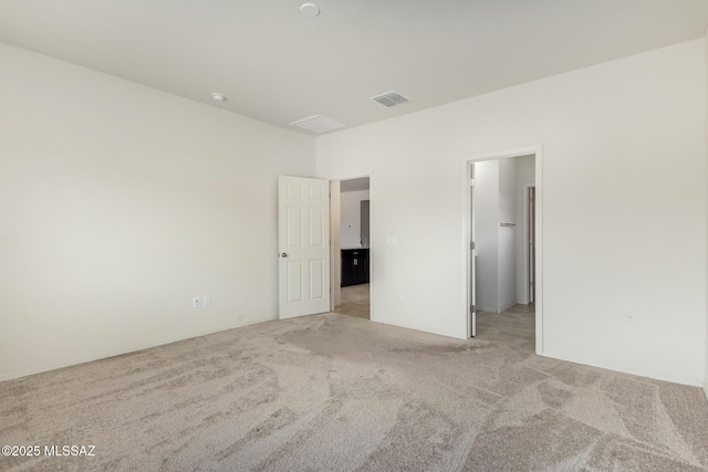 unfurnished bedroom featuring a spacious closet, light colored carpet, and a closet