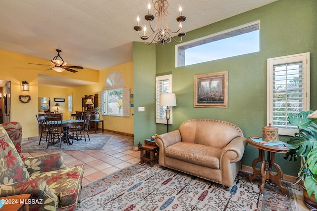 tiled living room featuring ceiling fan with notable chandelier and a textured ceiling