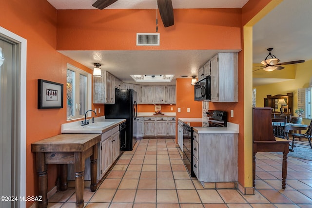 kitchen featuring ceiling fan, sink, light tile patterned floors, and black appliances