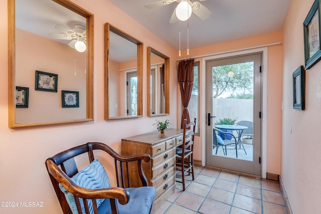 doorway with light tile patterned floors and ceiling fan