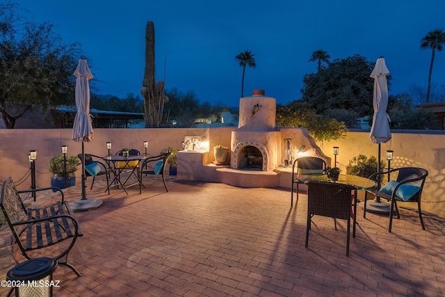 patio at night with exterior fireplace