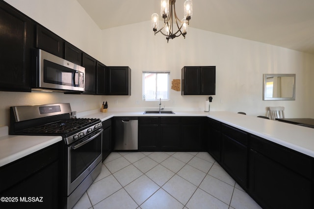 kitchen with hanging light fixtures, appliances with stainless steel finishes, sink, light tile patterned floors, and lofted ceiling