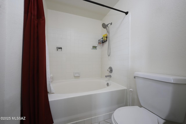 bathroom with toilet and tiled shower / bath