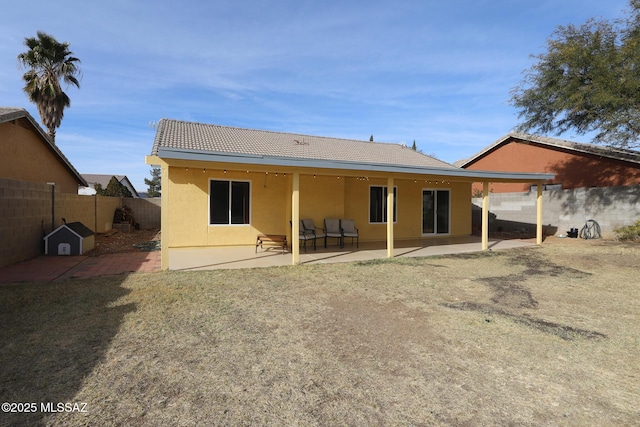 back of property featuring a patio area and a yard