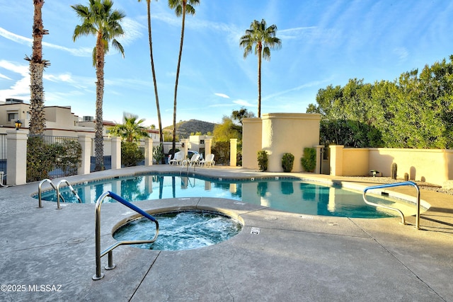 view of swimming pool featuring a hot tub and a patio