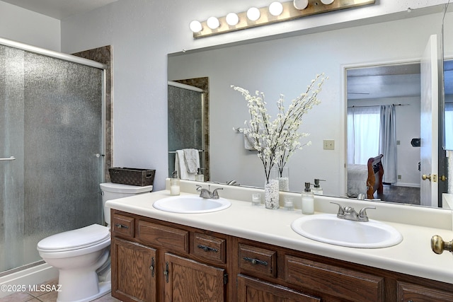 bathroom featuring tile patterned floors, vanity, toilet, and a shower with shower door