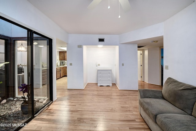 living room featuring ceiling fan and light hardwood / wood-style flooring