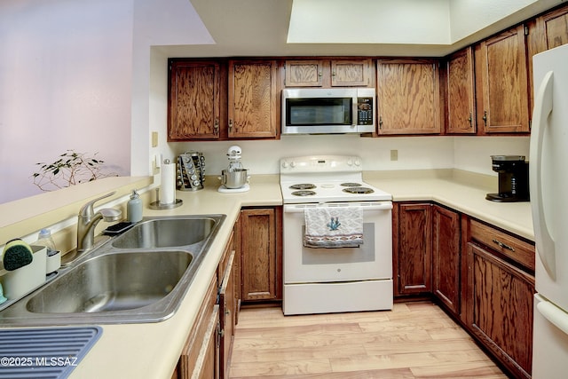 kitchen featuring sink, white appliances, and light hardwood / wood-style floors