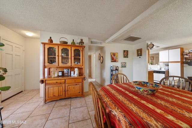 tiled dining room featuring a textured ceiling