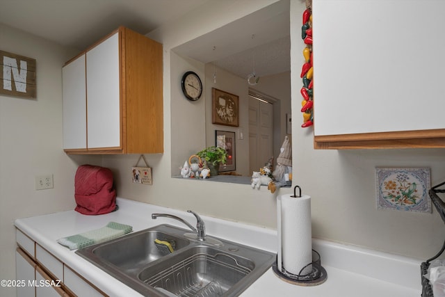 kitchen featuring white cabinetry and sink