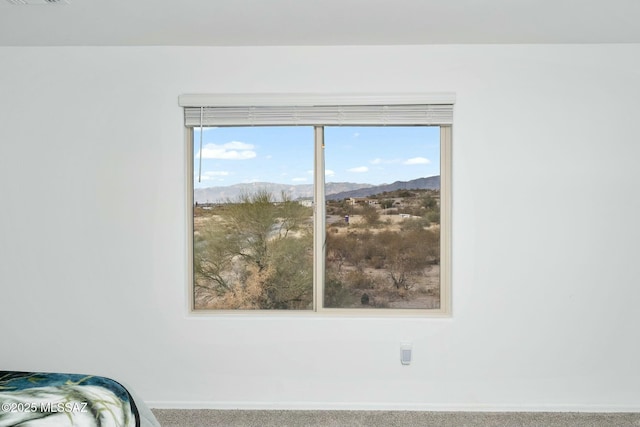 bedroom with a mountain view and carpet flooring