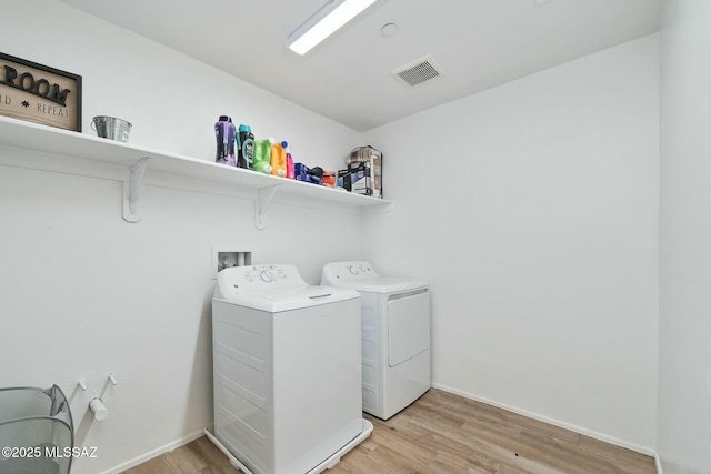 clothes washing area featuring light hardwood / wood-style flooring and independent washer and dryer