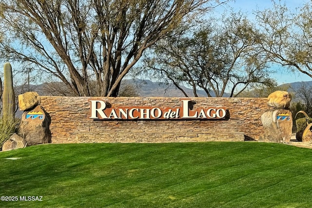 community / neighborhood sign featuring a mountain view and a yard