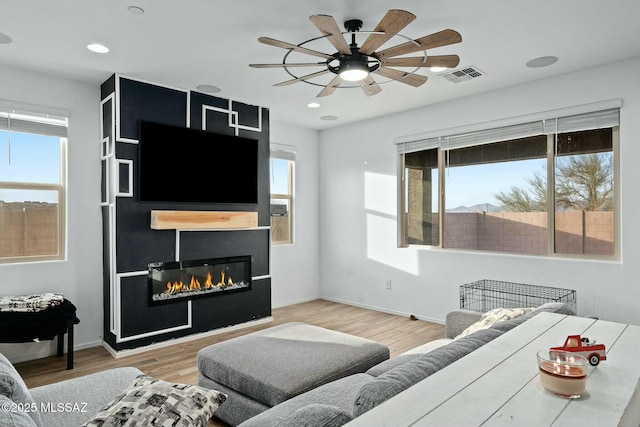 living room featuring wood-type flooring and ceiling fan