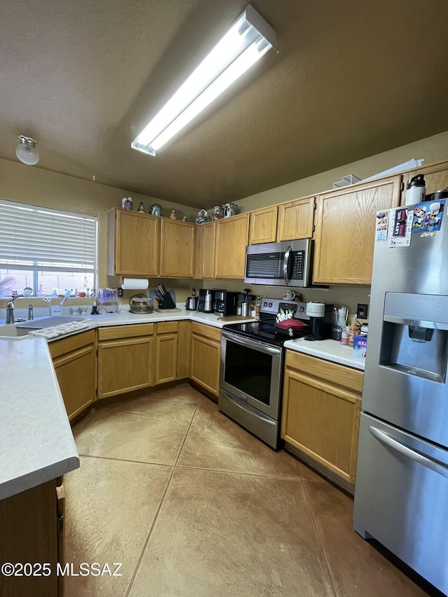 kitchen with sink, light tile patterned floors, and stainless steel appliances